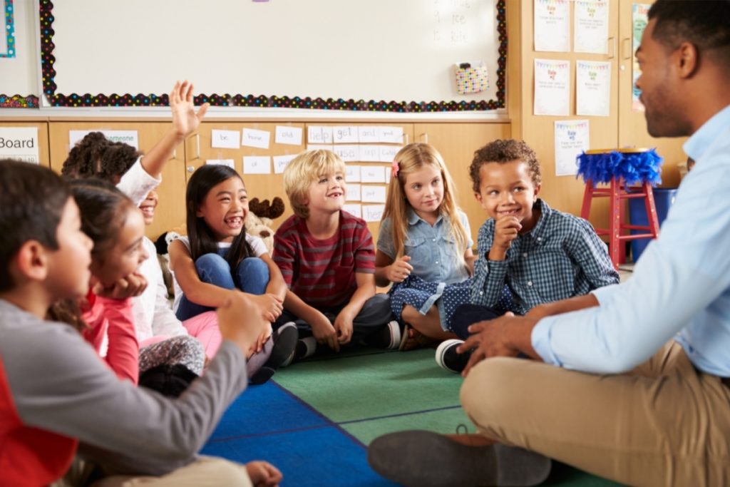 Un éducateur Montessori fait une présentation orale à un groupe d'enfants de 6 à 12 ans.